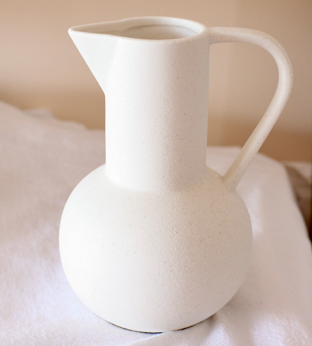 White ceramic pitcher vase on shelf