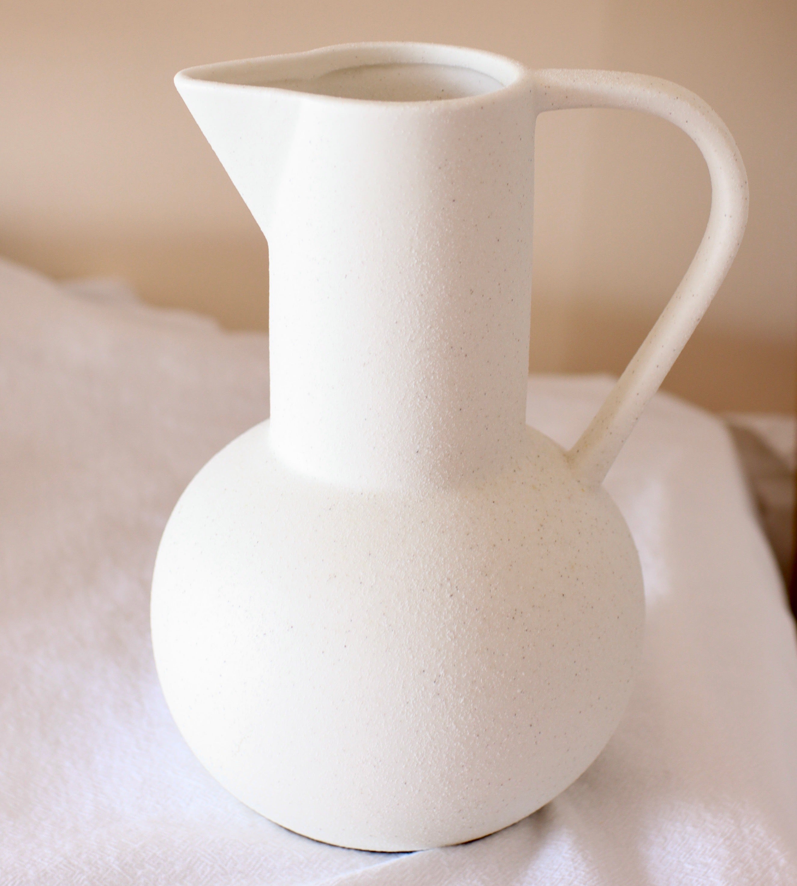 White ceramic pitcher vase on shelf