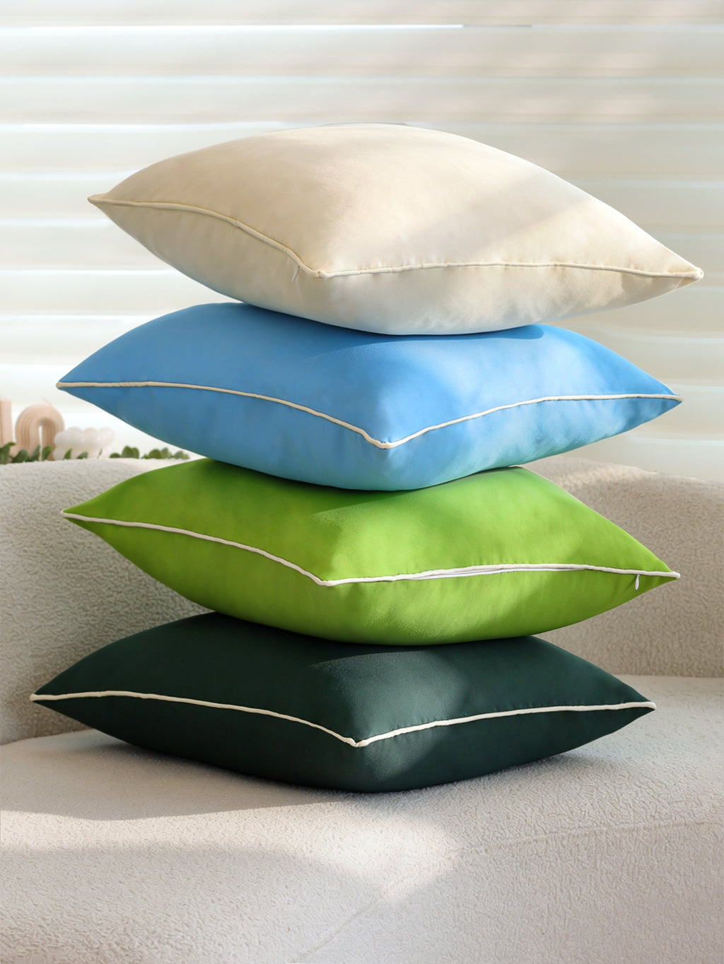 Solid cream outdoor throw pillow on sofa