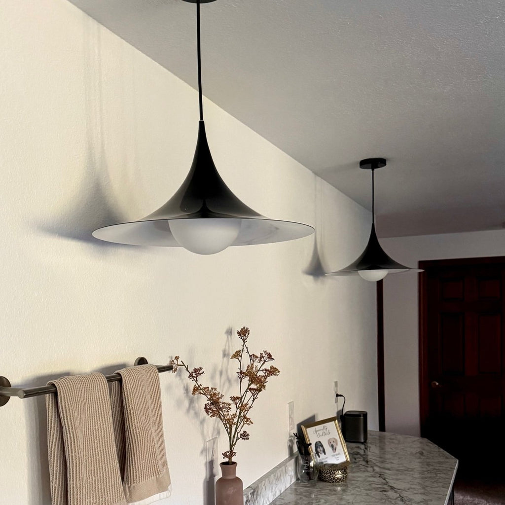 Black trumpet pendant light over a kitchen island