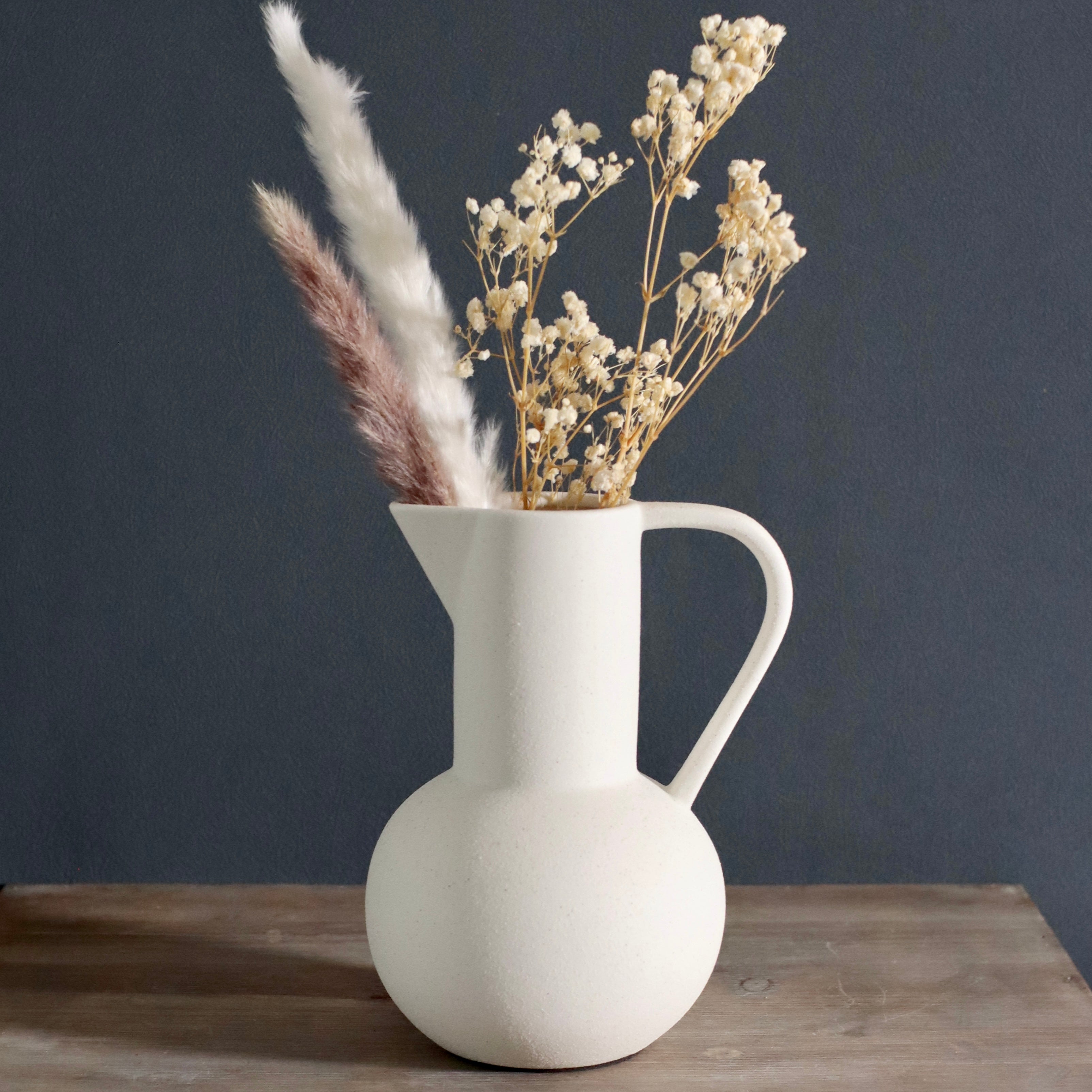 White ceramic vase with dried flowers
