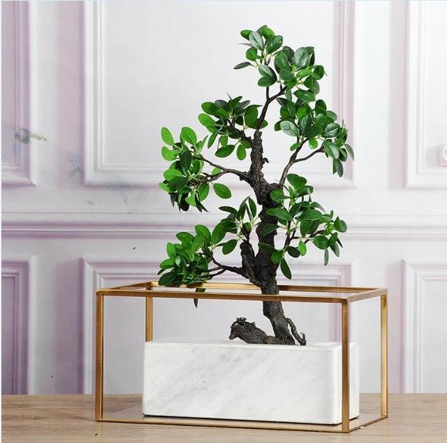 Gold metal frame vase with single stem flower