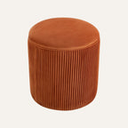 Round velvet ottoman in a modern living room setting