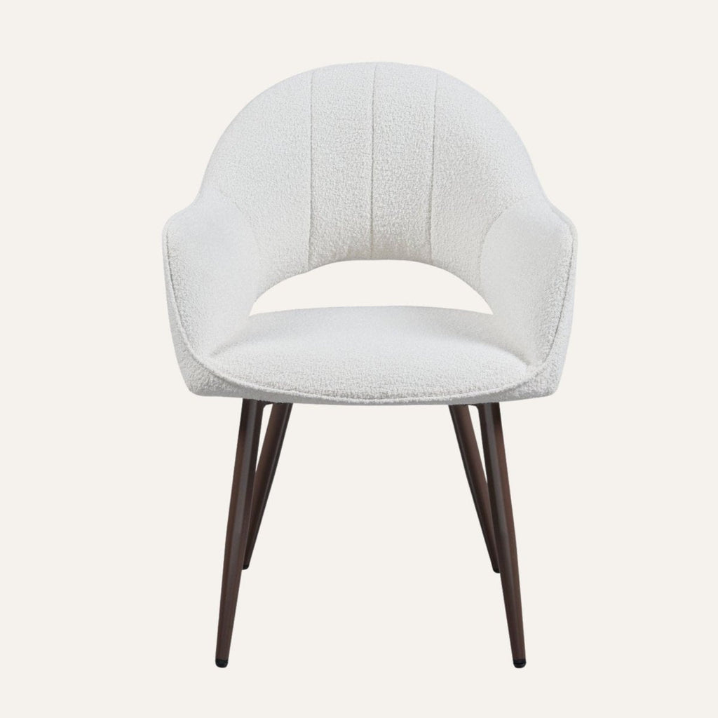 Contemporary dining chairs in ivory boucle around a dining table